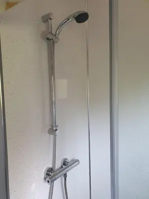 a shower with a shower head in a bathroom at Delightful shepherd's hut in a rural location in North Fambridge