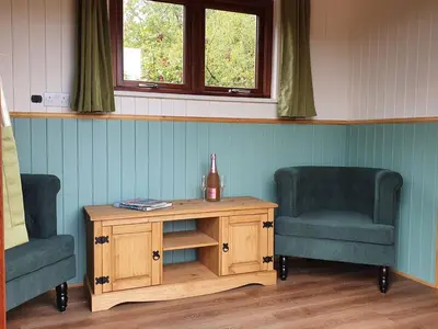 two chairs and a table in a room with two chairs at Delightful shepherd's hut in a rural location in North Fambridge
