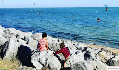 two young boys sitting on rocks on the beach at Two Bed Flat By The Beach No Parties No Events in Southend-on-Sea