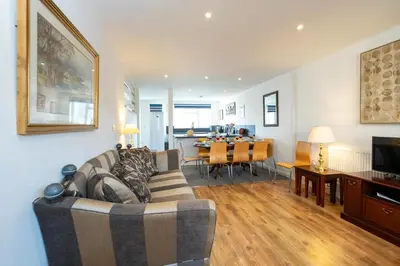 a living room with a couch and a dining room at 7 The Plantation - Aldeburgh Coastal Cottages in Aldeburgh