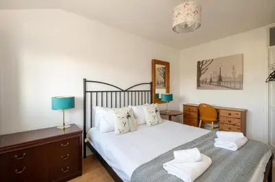 a bedroom with a bed with two lamps and a dresser at 7 The Plantation - Aldeburgh Coastal Cottages in Aldeburgh