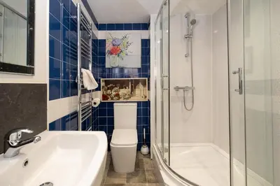 a bathroom with a toilet and a sink and a shower at 7 The Plantation - Aldeburgh Coastal Cottages in Aldeburgh