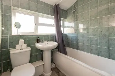 a bathroom with a toilet and a sink and a tub at 7 The Plantation - Aldeburgh Coastal Cottages in Aldeburgh
