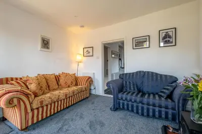a living room with a couch and a chair at 7 Coastguards Cottages - Aldeburgh Coastal Cottages in Aldeburgh