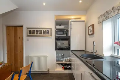 a kitchen with a sink and a counter top at 7 Coastguards Cottages - Aldeburgh Coastal Cottages in Aldeburgh