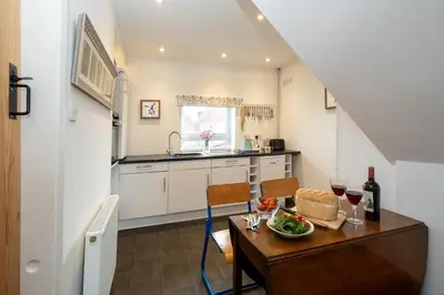 a kitchen with a table with a bowl of food on it at 7 Coastguards Cottages - Aldeburgh Coastal Cottages in Aldeburgh