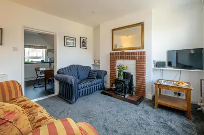 a living room with a couch and a fireplace at 7 Coastguards Cottages - Aldeburgh Coastal Cottages in Aldeburgh