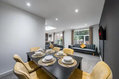 a dining room with a table and chairs at Modern Comfort 4BR Home for 10 in North Weald
