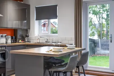 a kitchen with a counter with two glasses of wine at Modern Comfort 4BR Home for 10 in North Weald