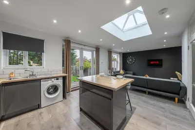 a kitchen with a washer and dryer in a house at Modern Comfort 4BR Home for 10 in North Weald