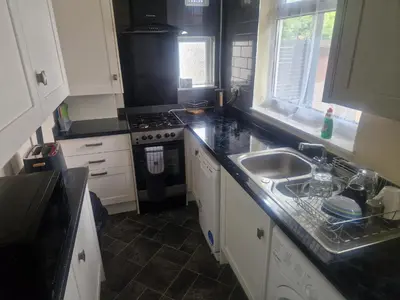 a kitchen with a sink and a stove at Arundel Road, RM30RX in Harold Wood