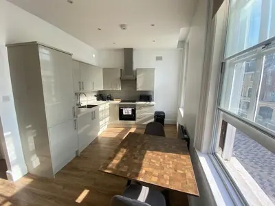 a kitchen with a table and a large window at The Essex Atelier Studio Flat 2 in Chelmsford