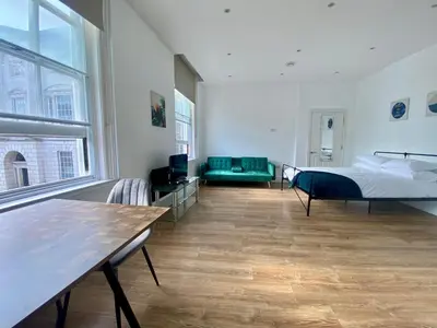 a bedroom with a bed and a couch and a table at The Essex Atelier Studio Flat 2 in Chelmsford