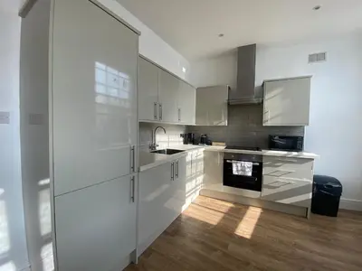a kitchen with white cabinets and a stove at The Essex Atelier Studio Flat 2 in Chelmsford