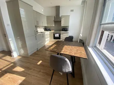 a kitchen with a table and chairs and a window at The Essex Atelier Studio Flat 2 in Chelmsford