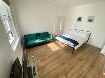 a bedroom with a bed and a couch at The Essex Atelier Studio Flat 2 in Chelmsford