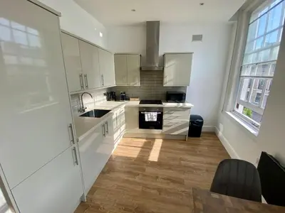 a kitchen with white cabinets and a sink at The Essex Atelier Studio Flat 2 in Chelmsford