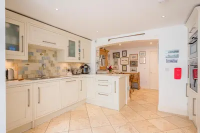 a kitchen with white cabinets and a tile floor at 207 High Street, Aldeburgh in Aldeburgh