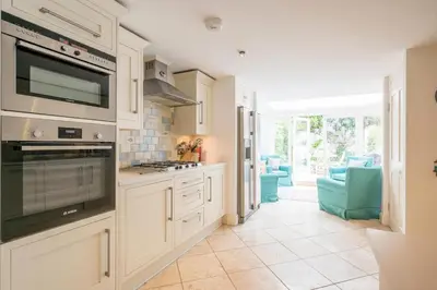 a kitchen with white cabinets and a stove top oven at 207 High Street, Aldeburgh in Aldeburgh