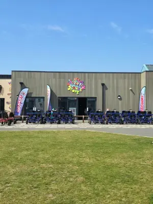 a building with blue tables and chairs in front of it at FI005 Loomy Escapes Caravan at St Osyth Beach Essex in Saint Osyth