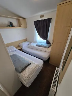 a small room with two beds and a window at FI005 Loomy Escapes Caravan at St Osyth Beach Essex in Saint Osyth
