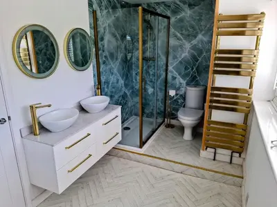 a bathroom with a shower and two sinks and a toilet at Modern townhouse with easy access to London in Ingatestone