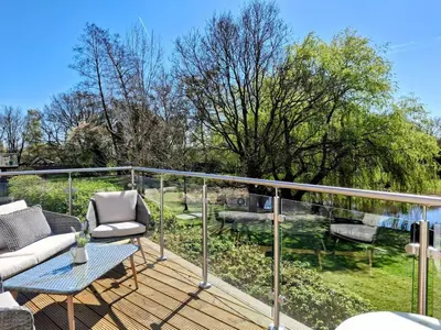 a balcony with a table and chairs on a deck at Modern townhouse with easy access to London in Ingatestone