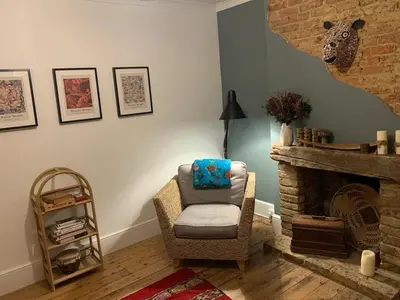 a living room with a chair and a fireplace at Homely flat just off Leigh Broadway in Southend-on-Sea