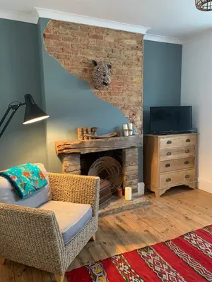 a living room with a chair and a fireplace at Homely flat just off Leigh Broadway in Southend-on-Sea