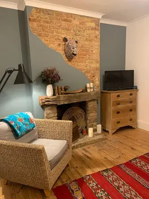 a living room with a chair and a fireplace at Homely flat just off Leigh Broadway in Southend-on-Sea