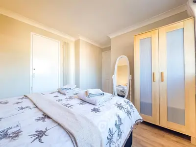 a bedroom with a bed and a mirror at Urban Ease Basildon in Basildon
