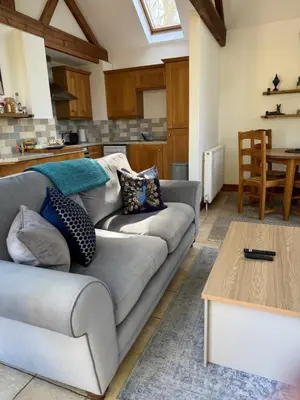 a living room with a couch and a table at Elm Barn in Diss