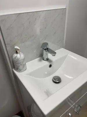 a white bathroom sink with a soap dispenser on it at Elm Barn in Diss