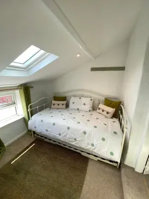 a bedroom with a white bed with pillows and a window at 5 chapel lane Wymondham Norfolk in Wymondham
