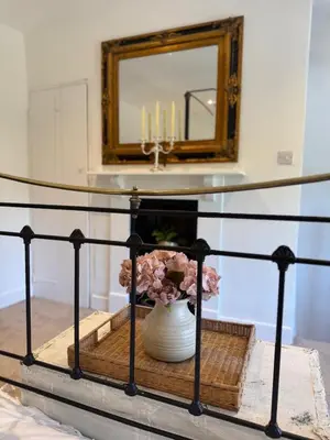 a table with a vase and a mirror with candles at 5 chapel lane Wymondham Norfolk in Wymondham