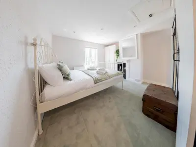 a white bedroom with a bed and a table at Magnolia Cottage your cosy Getaway Pass the Keys in Chelmsford