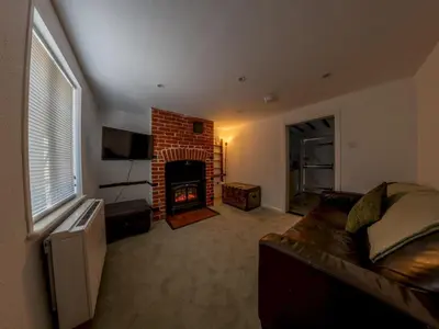 a living room with a couch and a fireplace at Magnolia Cottage your cosy Getaway Pass the Keys in Chelmsford
