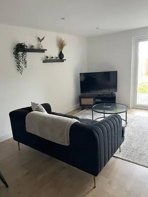a living room with a couch and a tv at 5 Bed Home near Anglesey Abbey in Swaffham Bulbeck
