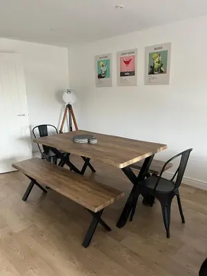 a wooden table with two chairs and a bench at 5 Bed Home near Anglesey Abbey in Swaffham Bulbeck