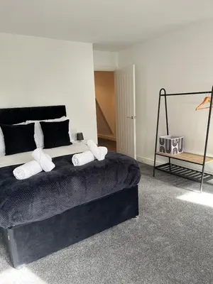 a bedroom with a large bed with white pillows at 5 Bed Home near Anglesey Abbey in Swaffham Bulbeck