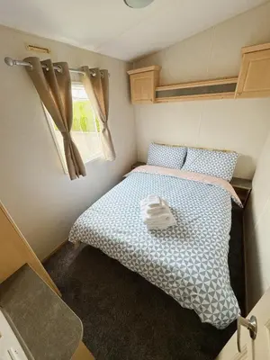 a small bedroom with a bed in a small room at Santos Caravan Beautiful Holiday Home in Clacton-on-Sea