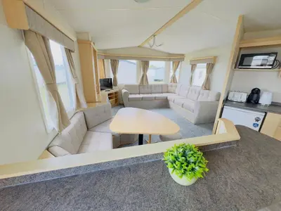 a living room with a couch and a table at Santos Caravan Beautiful Holiday Home in Clacton-on-Sea