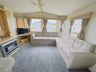 a living room with a couch and a television at Santos Caravan Beautiful Holiday Home in Clacton-on-Sea