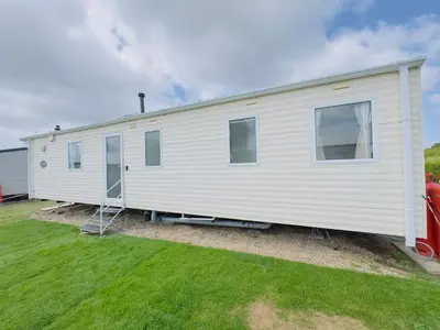 a white mobile home sitting on top of a yard at Santos Caravan Beautiful Holiday Home in Clacton-on-Sea