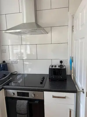 a kitchen with a stove top oven in a room at Holly Copse in Stevenage