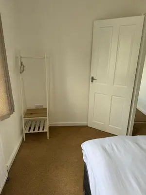 a bedroom with a white door and a bed at Holly Copse in Stevenage