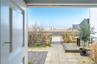 an open door to a patio with a view at Edinburgh House 4 in Aldeburgh