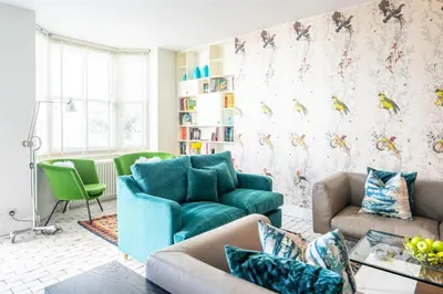 a living room with a blue couch and green chairs at Edinburgh House 4 in Aldeburgh