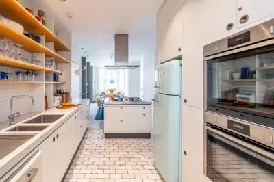 a kitchen with white cabinets and a tile floor at Edinburgh House 4 in Aldeburgh