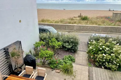 a balcony with a bench and a view of the beach at Edinburgh House 4 in Aldeburgh